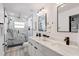 Bright bathroom featuring a double vanity, marble countertops, modern fixtures, and a marble tile shower at 4907 21St W Ave, Bradenton, FL 34209