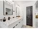 Bathroom featuring a double vanity, marble countertops, modern fixtures, and a dark wood door at 4907 21St W Ave, Bradenton, FL 34209