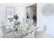 Dining room with glass table and white chairs. View to laundry room and lounge area at 3711 Huntington Ne St, St Petersburg, FL 33703