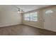Bright living room showcasing new floors, a ceiling fan, and natural light coming through a large window at 4129 Highland Loop, New Port Richey, FL 34652