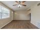 Open living room with updated flooring, a ceiling fan, and natural light at 4129 Highland Loop, New Port Richey, FL 34652
