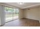 View of bright living room with hardwood floors and sliding glass doors to the backyard at 4129 Highland Loop, New Port Richey, FL 34652