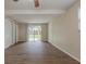 View of bright living room with hardwood floors, two closets, and sliding glass doors to the backyard at 4129 Highland Loop, New Port Richey, FL 34652