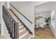 Staircase with black handrail looking into the dining room and living room at 5303 Glen Harwell Rd, Plant City, FL 33566