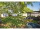 Large backyard featuring mature shade trees, multiple storage sheds, and a screened in porch at 7004 24Th S Ave, Tampa, FL 33619