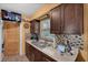 Well-lit kitchen with stainless steel sink, granite countertops, and dark wood cabinetry at 7004 24Th S Ave, Tampa, FL 33619