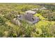 Aerial view of a home with solar panels and a screened-in pool surrounded by dense trees at 1570 Oakford Rd, Sarasota, FL 34240