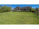 Sprawling backyard with lush green grass, beautiful hedges, and a screened-in back porch at 1570 Oakford Rd, Sarasota, FL 34240