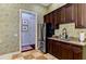 Butler's pantry with stainless refrigerator, granite countertop, sink and custom cabinets at 1570 Oakford Rd, Sarasota, FL 34240