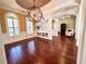 Open dining space featuring hardwood floors, architectural columns, wainscoting, and an ornate chandelier at 1570 Oakford Rd, Sarasota, FL 34240
