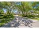 Long, patterned driveway leading to a traditional home shaded by mature trees at 1570 Oakford Rd, Sarasota, FL 34240
