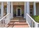 Inviting front porch with brick steps, stately columns, and a stylish front door with decorative plants at 1570 Oakford Rd, Sarasota, FL 34240