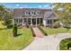 Beautiful two-story home with mature landscaping, a brick driveway, and a welcoming front porch at 1570 Oakford Rd, Sarasota, FL 34240