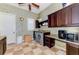 Functional laundry room with floral wallpaper, dark wood cabinets and granite countertops at 1570 Oakford Rd, Sarasota, FL 34240