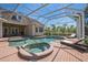 Outdoor in-ground screened-in pool and hot tub with brick pavers and lounge chairs at 1570 Oakford Rd, Sarasota, FL 34240