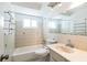 Classic bathroom with tub, tiled walls, a large mirror, and neutral fixtures at 10105 Vineyard Ln, Port Richey, FL 34668