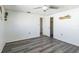 Neutral bedroom with gray wood-look flooring, a ceiling fan, and closet access at 10105 Vineyard Ln, Port Richey, FL 34668