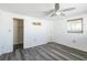 Clean bedroom with gray wood-look flooring, neutral walls, closet, and a ceiling fan at 10105 Vineyard Ln, Port Richey, FL 34668