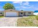 Charming single-story home featuring an attached garage, brick driveway, and a well-maintained front lawn at 10105 Vineyard Ln, Port Richey, FL 34668