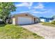 Front exterior of home with brick driveway, garage, trimmed lawn and porch with white decorative fencing at 10105 Vineyard Ln, Port Richey, FL 34668