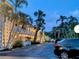 Exterior view of building featuring palm trees and parking area at dusk at 2155 Wood St # B4, Sarasota, FL 34237