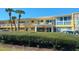 Well-maintained yellow building with lush landscaping, covered entrance, and ample parking at 2155 Wood St # B4, Sarasota, FL 34237