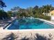 A spacious community pool is surrounded by lush trees and verdant foliage at 2155 Wood St # B4, Sarasota, FL 34237