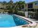 Sparkling community pool with adjacent seating and lush landscaping, reflecting the building's facade at 2155 Wood St # B4, Sarasota, FL 34237