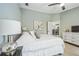 Well-lit bedroom with a large bed, painting, and entry to kitchen at 13004 Waterbourne Dr, Gibsonton, FL 33534