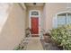 Close-up of the inviting red front door, flanked by plants, and a window above the doorway at 13004 Waterbourne Dr, Gibsonton, FL 33534