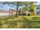 Attractive one-story home with a red door, an attached garage, and lush front lawn with mature landscaping at 13004 Waterbourne Dr, Gibsonton, FL 33534
