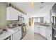 Modern kitchen with white cabinets, stainless steel appliances, and open layout with bar stool seating at 13004 Waterbourne Dr, Gibsonton, FL 33534