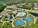 Aerial view of community park featuring tennis courts, clubhouse, pool and playground in a lushly landscaped area at 13136 Peregrin Cir, Bradenton, FL 34212