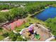 Aerial view of community playground, splashpad, and basketball court near a beautiful lake and lush landscape at 13136 Peregrin Cir, Bradenton, FL 34212