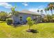 A well-manicured backyard with lush landscaping, an enclosed porch, and a small tree at 13136 Peregrin Cir, Bradenton, FL 34212