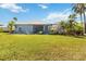 A well-manicured backyard with lush landscaping, an enclosed porch, and bright green grass at 13136 Peregrin Cir, Bradenton, FL 34212
