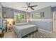 Comfortable gray bedroom with a beachy decor, ceiling fan, and wood-look floors at 13136 Peregrin Cir, Bradenton, FL 34212