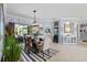Dining room with modern chandelier, view to living room, and lots of natural light at 13136 Peregrin Cir, Bradenton, FL 34212