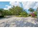 Paver driveway with lush landscaping and mature trees offering ample parking at 13136 Peregrin Cir, Bradenton, FL 34212