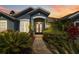 Elegant front entrance with decorative glass doors surrounded by lush tropical landscaping at 13136 Peregrin Cir, Bradenton, FL 34212