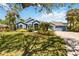 Charming single-story home featuring mature landscaping, a brick driveway, and a welcoming facade at 13136 Peregrin Cir, Bradenton, FL 34212