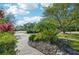 Well manicured landscaping features lush tropical plants and a brick paver walkway at 13136 Peregrin Cir, Bradenton, FL 34212