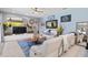 Spacious living room featuring a large flat-screen TV, comfortable seating, and ample natural light at 13136 Peregrin Cir, Bradenton, FL 34212
