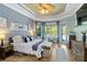 Bright and airy primary bedroom with tray ceilings, wood floors, and backyard views at 13136 Peregrin Cir, Bradenton, FL 34212