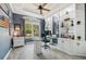 Bright home office featuring built-in shelving, wood-look tile floors, tray ceiling, and a glass top desk at 13136 Peregrin Cir, Bradenton, FL 34212