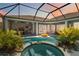 Inviting screened-in pool and spa area with lush landscaping, offering a private outdoor retreat at 13136 Peregrin Cir, Bradenton, FL 34212