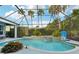 Screened-in pool with waterfall feature, surrounding greenery and blue skies overhead at 13136 Peregrin Cir, Bradenton, FL 34212