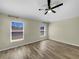 Sun-filled bedroom with wood-look floors, large windows, and neutral paint at 15452 Long Cypress Dr, Ruskin, FL 33573