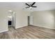 Main bedroom with wood floors and a ceiling fan, with easy access to the bathroom at 15452 Long Cypress Dr, Ruskin, FL 33573
