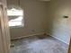 Empty room featuring a damaged window, bare walls, and a dirty concrete floor, presenting renovation potential at 2918 E Waters Ave, Tampa, FL 33604
